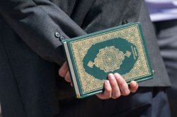 A man holds a Holy Quran as guests and worshippers arrive at an Islamic Janazah service at Freedom Hall on June 8, 2016 in Louisville, Kentucky.